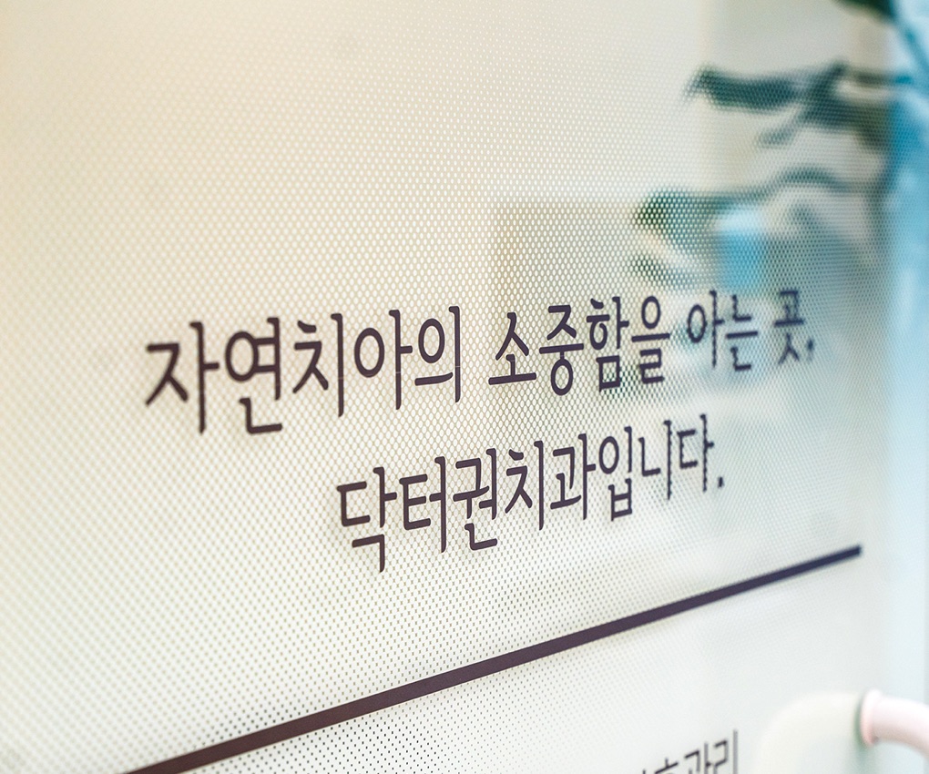 「자연치아의 소중함을 아는 곳, 닥터권치과입니다」라고 적힌 진료실 유리벽